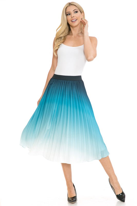 A woman with long blonde hair wears a black sleeveless top paired with the Women's High Waist Pleated A-Line Swing skirt featuring a purple to white gradient pleat and black ballet flats. She poses with one arm slightly bent and the other at her side.