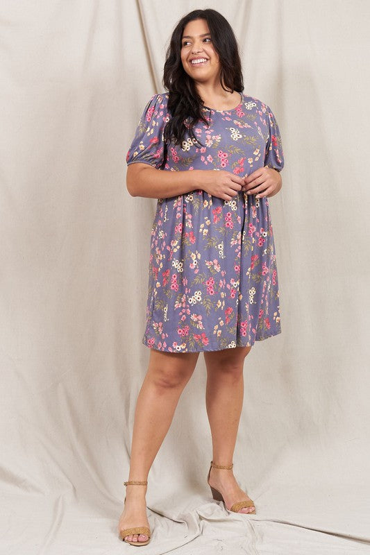 Woman wearing a Gathered Puff Sleeve Mini Dress in blue floral, made with a Polyester Spandex blend, standing against a plain white background.