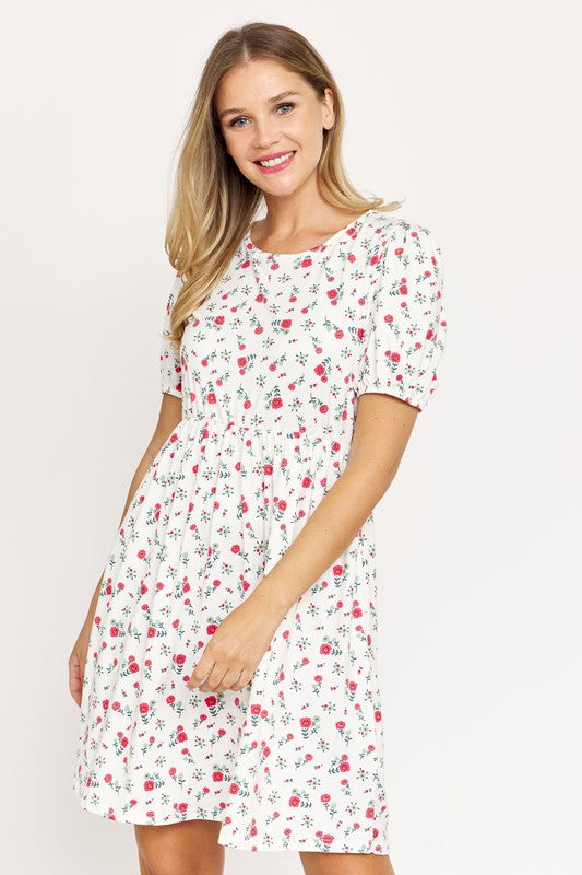 Woman wearing a Gathered Puff Sleeve Mini Dress in blue floral, made with a Polyester Spandex blend, standing against a plain white background.