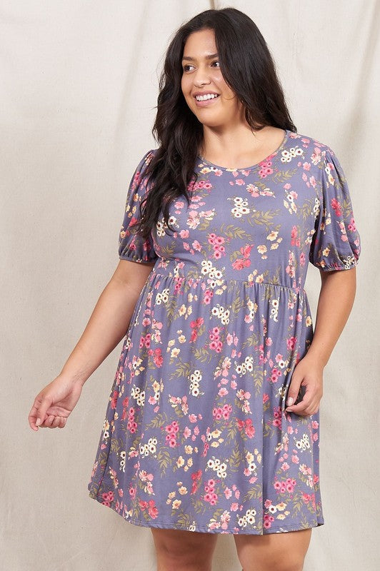 Woman wearing a Gathered Puff Sleeve Mini Dress in blue floral, made with a Polyester Spandex blend, standing against a plain white background.