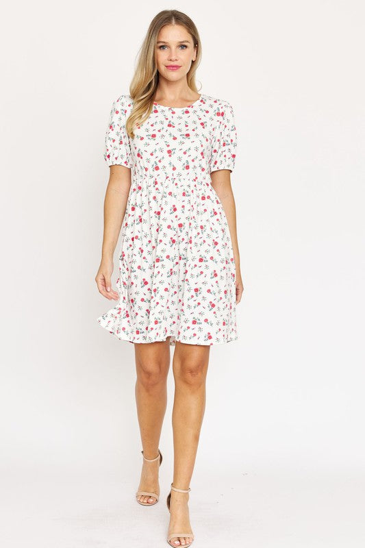 Woman wearing a Gathered Puff Sleeve Mini Dress in blue floral, made with a Polyester Spandex blend, standing against a plain white background.