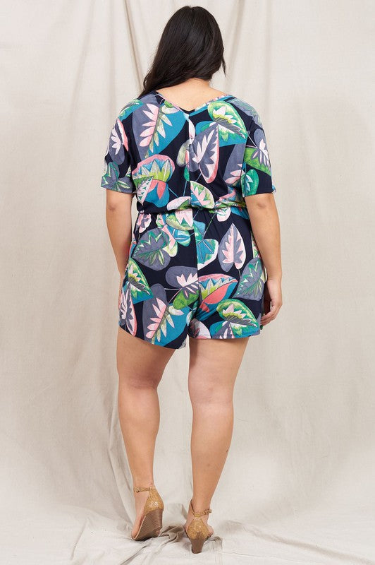 A person wearing a Plus Tropical Kimono Sleeve Romper is smiling, standing against a neutral background.