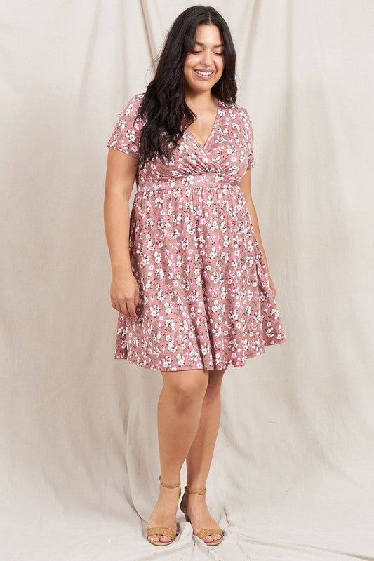 A person wearing a Plus Ditsy Surplice Fit and Flare Midi Dress stands in front of a beige curtain, smiling warmly.