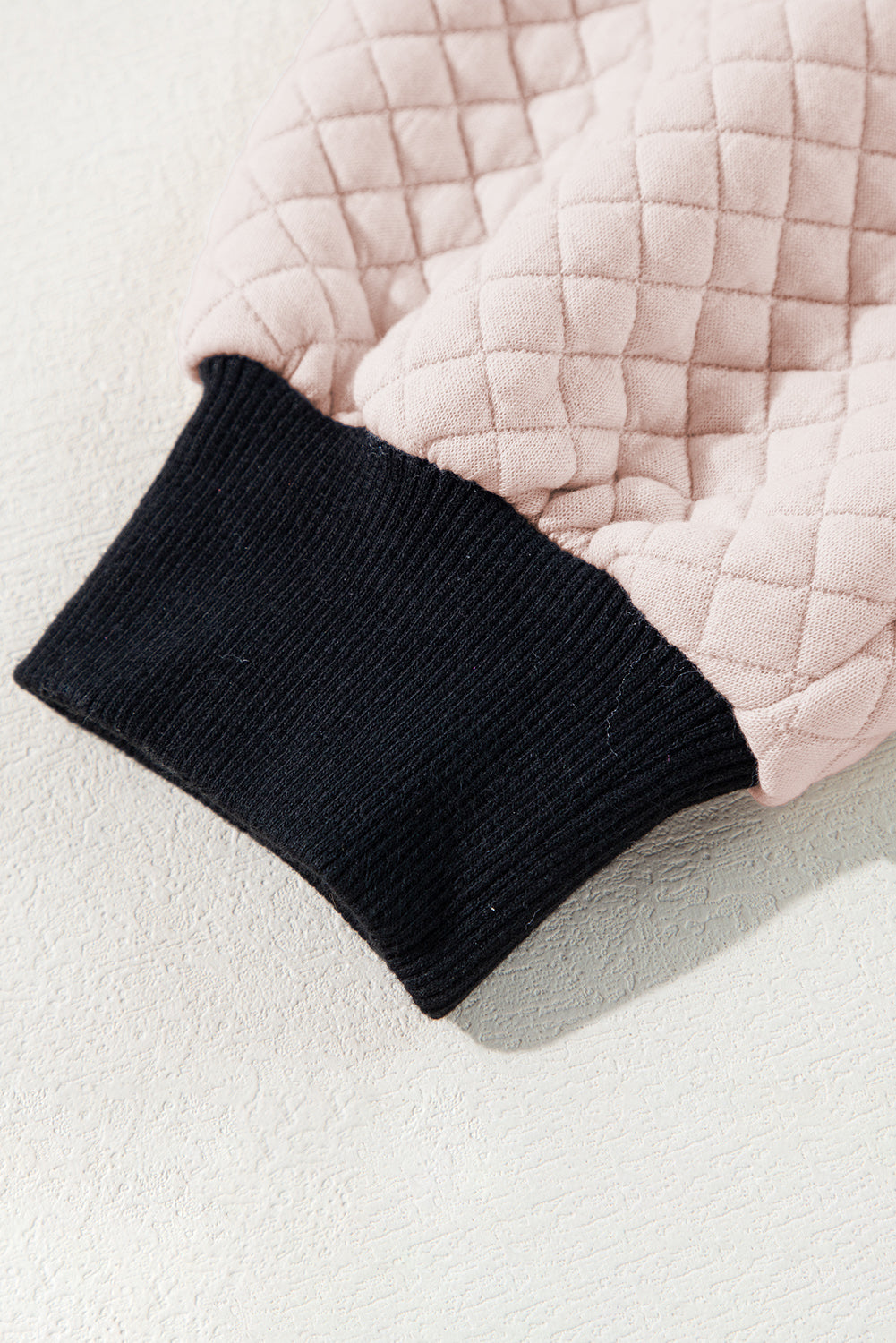 A person wearing an Oatmeal Textured Colorblock Edge Buttoned Collar Sweatshirt, paired with blue jeans, stands with their back to the camera against a white backdrop. The trendy sweatshirt features stylish textured fabric and buttoned collars that add an extra touch of sophistication.