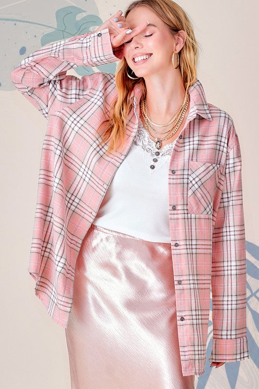A woman wearing the Dreamy Shirt, a pink plaid print top, over a white crochet crop top and white distressed shorts, standing against a light gray background.
