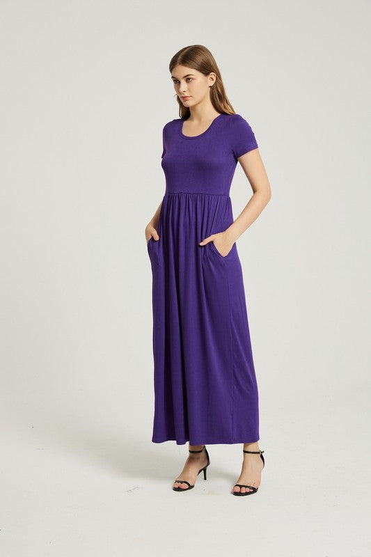 A woman elegantly poses against a plain background, wearing the vibrant Women's Summer Casual Maxi Dress With Pocket in purple, featuring short sleeves.