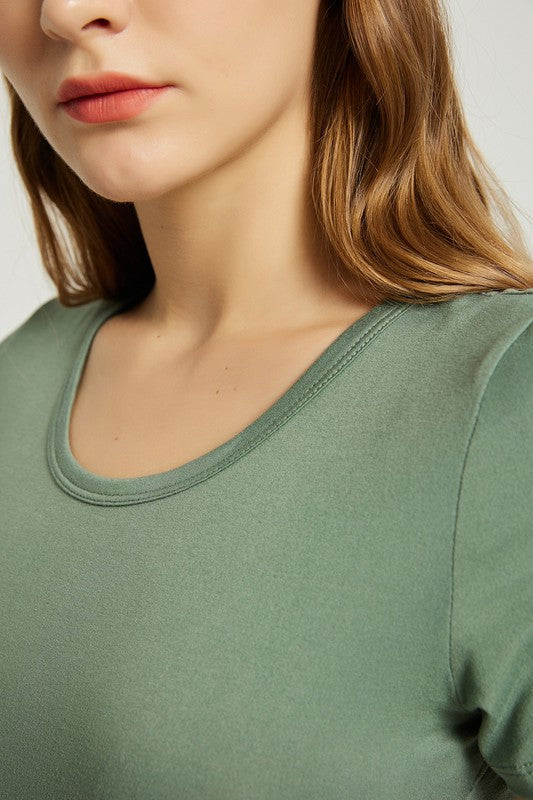 A woman wearing a Women's Summer Casual Maxi Dress With Pocket in green is seated on a white chair against a plain background.