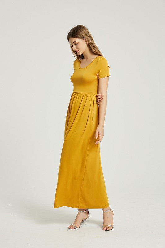 A person elegantly stands against a light gray background, wearing the Women's Summer Casual Maxi Dress With Pocket in mustard yellow, featuring short sleeves.