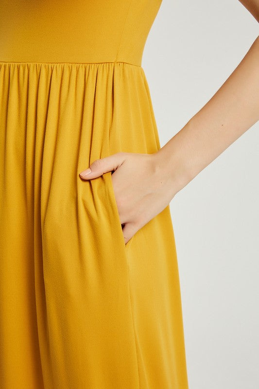 A person elegantly stands against a light gray background, wearing the Women's Summer Casual Maxi Dress With Pocket in mustard yellow, featuring short sleeves.