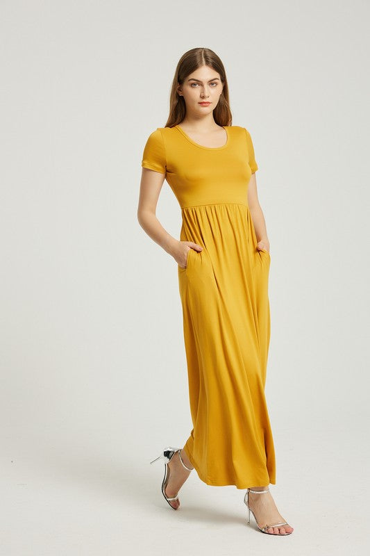 A person elegantly stands against a light gray background, wearing the Women's Summer Casual Maxi Dress With Pocket in mustard yellow, featuring short sleeves.