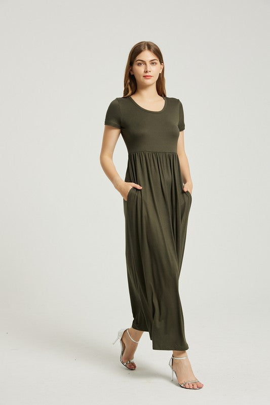 A person with straight hair is wearing a short-sleeved, floor-length dark green Women's Summer Casual Maxi Dress With Pocket and beige high-heeled sandals. They are standing against a plain white background.