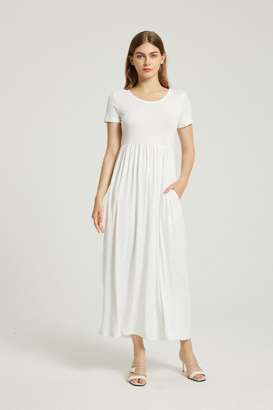 A woman in a white, short-sleeve, ankle-length Women's Summer Casual Maxi Dress With Pocket poses against a plain background. She is wearing white open-toed heels.