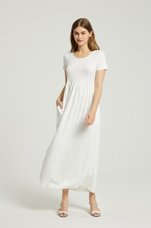 A woman in a white, short-sleeve, ankle-length Women's Summer Casual Maxi Dress With Pocket poses against a plain background. She is wearing white open-toed heels.