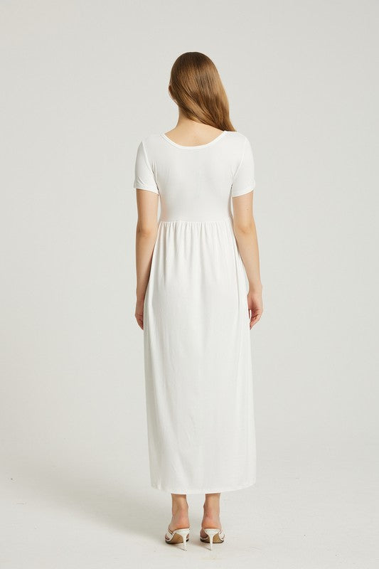 A woman in a white, short-sleeve, ankle-length Women's Summer Casual Maxi Dress With Pocket poses against a plain background. She is wearing white open-toed heels.
