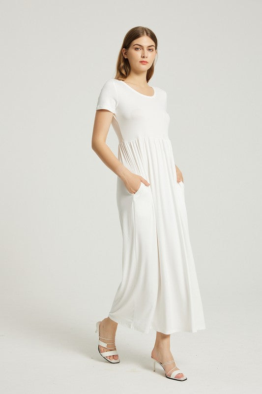 A woman in a white, short-sleeve, ankle-length Women's Summer Casual Maxi Dress With Pocket poses against a plain background. She is wearing white open-toed heels.