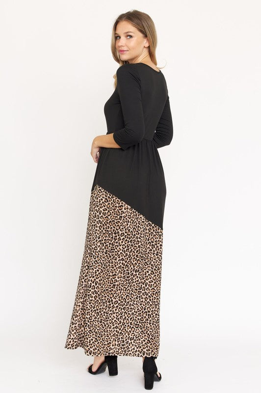 A woman wearing an Asymmetrical Leopard Accent Maxi Dress, made from polyester and featuring convenient pockets, stands against a plain white background.