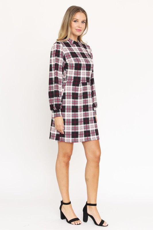 A woman stands smiling, wearing the High Neck Plaid Sheath Dress featuring a classic United States style in black, white, and red plaid with long sleeves.