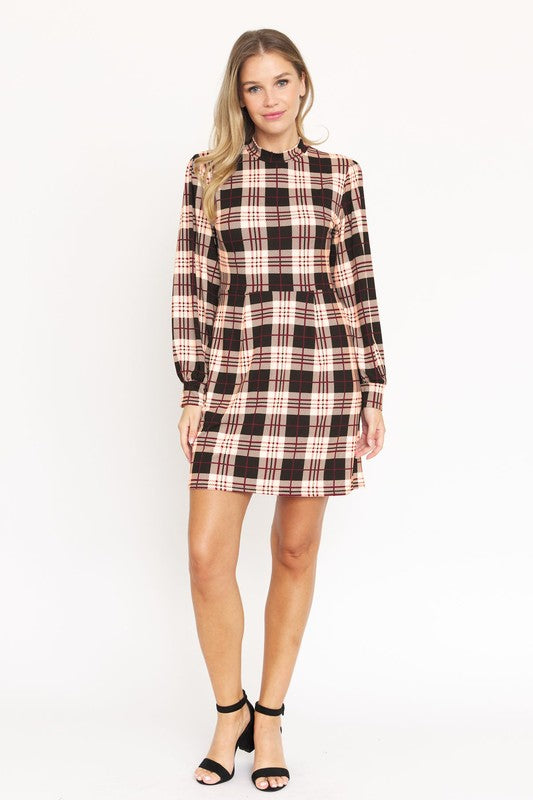 A woman stands smiling, wearing the High Neck Plaid Sheath Dress featuring a classic United States style in black, white, and red plaid with long sleeves.