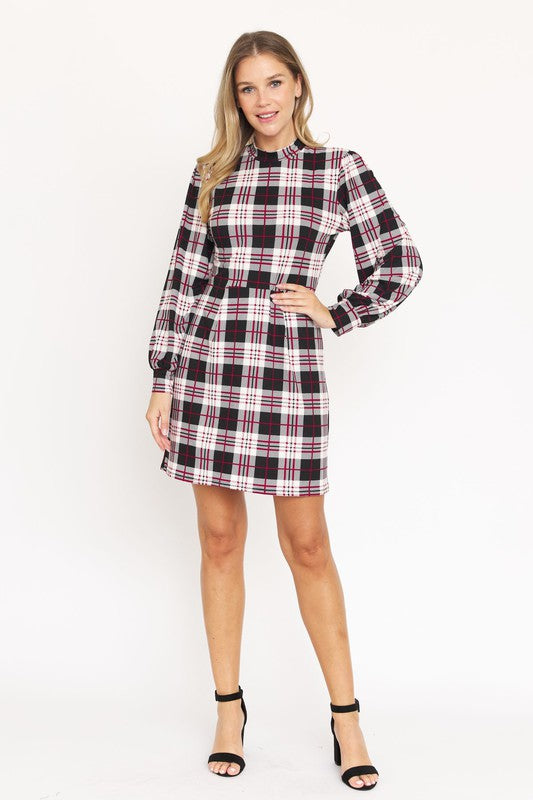 A woman stands smiling, wearing the High Neck Plaid Sheath Dress featuring a classic United States style in black, white, and red plaid with long sleeves.