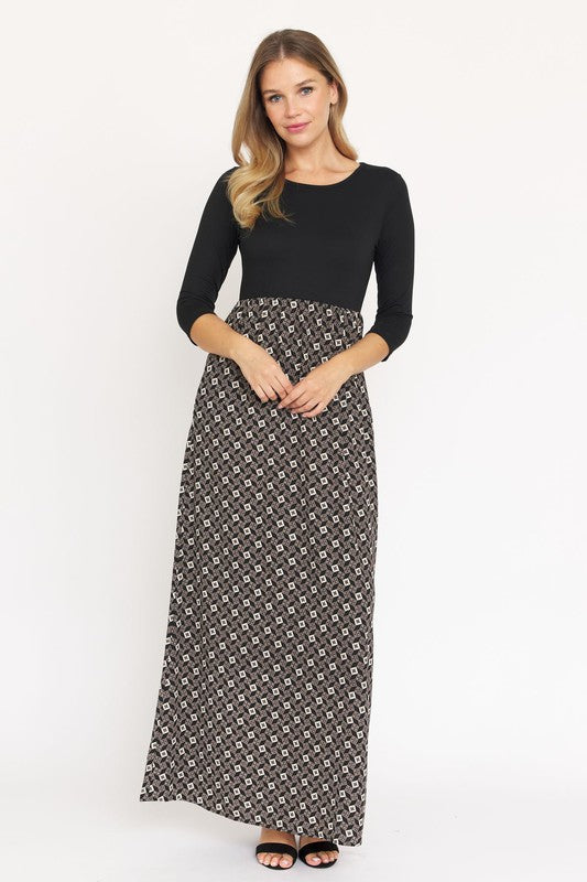 A woman with blonde hair elegantly models a Quarter Sleeve Maxi Dress, featuring intricate patterns and crafted in the United States, against a plain white background.