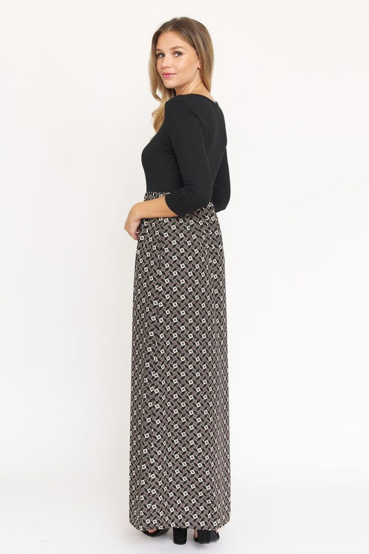 A woman with blonde hair elegantly models a Quarter Sleeve Maxi Dress, featuring intricate patterns and crafted in the United States, against a plain white background.