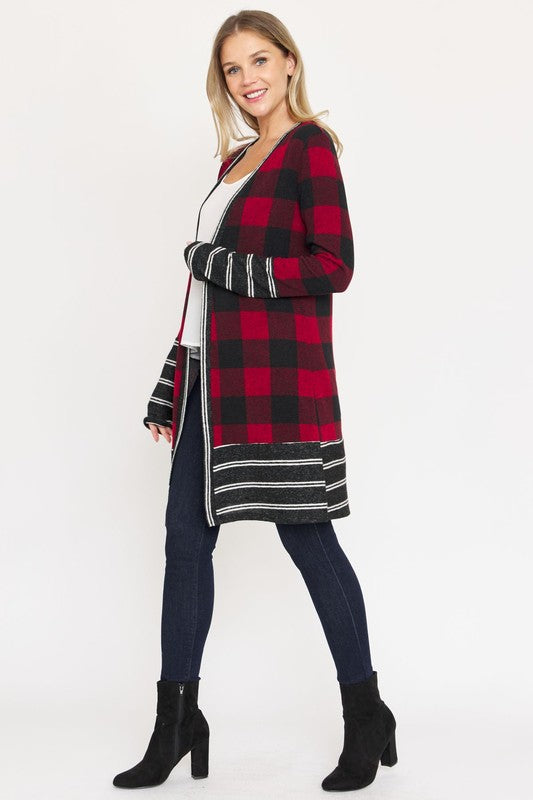 A woman wearing a Long Buffalo Plaid Stripe Trim Open Cardigan over a white top and dark jeans stands against a plain background.