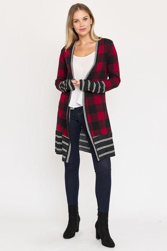 A woman wearing a Long Buffalo Plaid Stripe Trim Open Cardigan over a white top and dark jeans stands against a plain background.