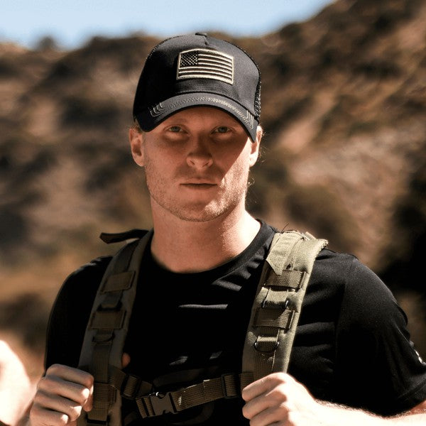 American Flag Unisex Trucker Hat with a navy blue front panel and breathable mesh back panel, perfect for outdoor activities.