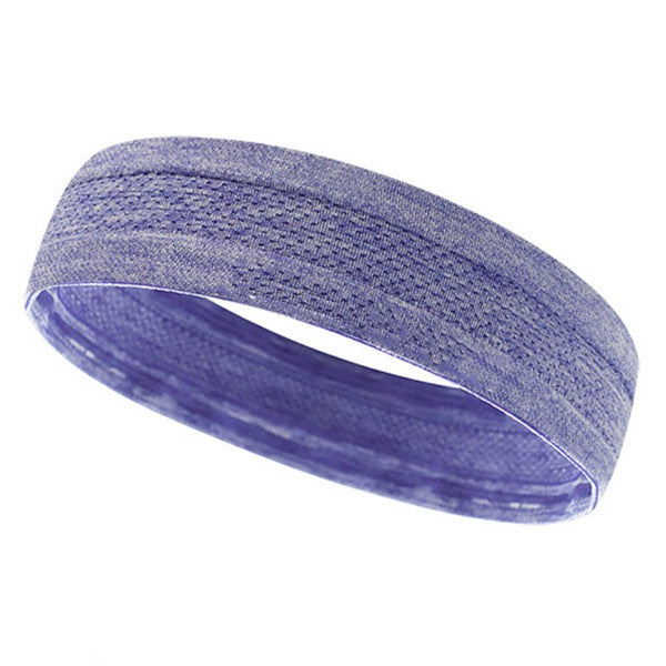 Woman with a pink Cardio Cross-Training Headband made of high-performance elastic fabric, standing against a black brick wall.