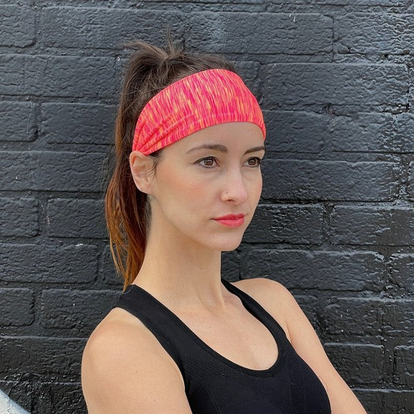 Woman with an Extra-Wide Sport Headband against a blue wall.