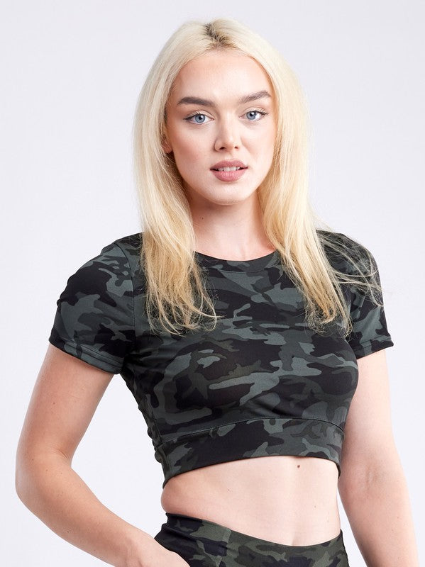 A person with long dark hair wears a fitted, olive green Short-Sleeve Crop Top and matching high-waisted leggings made from breathable material, standing against a plain white background.