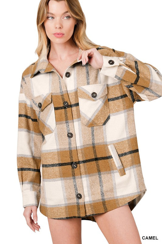 Woman wearing the Oversized Yarn Dyed Plaid Shacket featuring a checkered, camel-colored button-up design with long sleeves and chest pockets, paired with denim shorts.