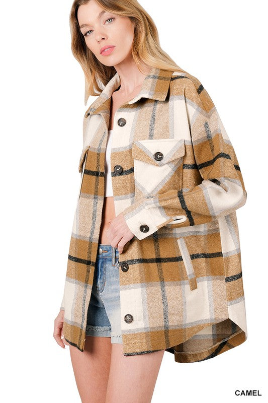 Woman wearing the Oversized Yarn Dyed Plaid Shacket featuring a checkered, camel-colored button-up design with long sleeves and chest pockets, paired with denim shorts.