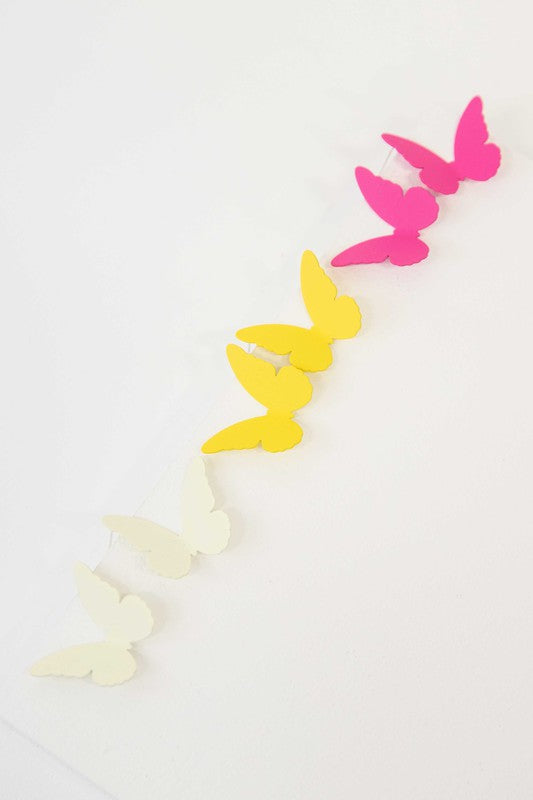 Flutter Post Earrings in a gradient from yellow to pink arranged in a diagonal line on a white background.