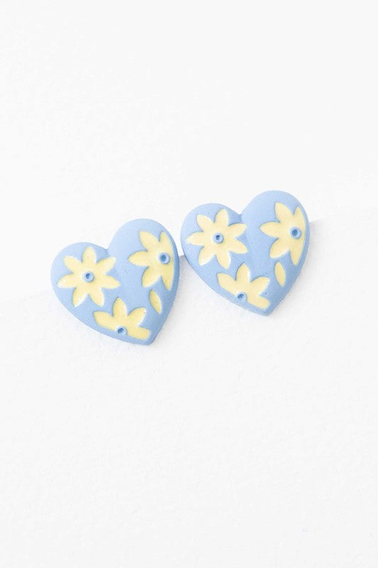 A diagonal line of Flower Lover Stud Earrings with floral patterns on a white background, featuring yellow stud hearts with Sterling Silver Posts.