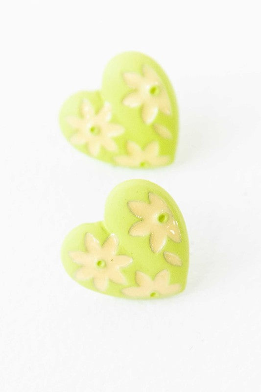 A diagonal line of Flower Lover Stud Earrings with floral patterns on a white background, featuring yellow stud hearts with Sterling Silver Posts.