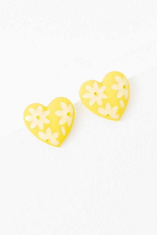 A diagonal line of Flower Lover Stud Earrings with floral patterns on a white background, featuring yellow stud hearts with Sterling Silver Posts.