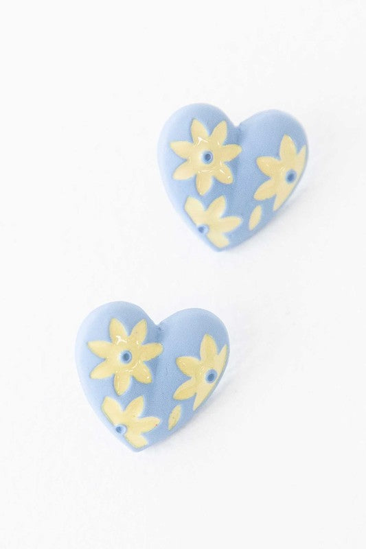 A diagonal line of Flower Lover Stud Earrings with floral patterns on a white background, featuring yellow stud hearts with Sterling Silver Posts.