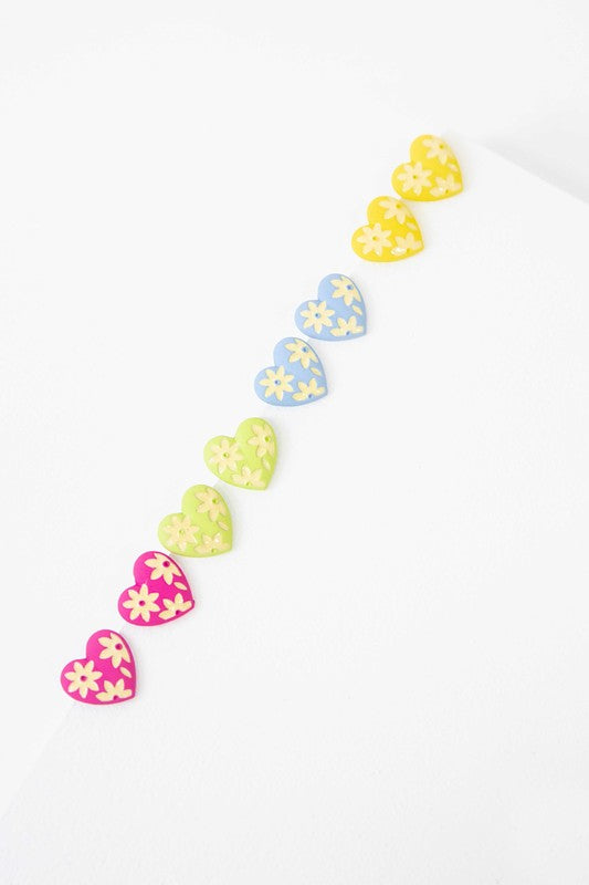 A diagonal line of Flower Lover Stud Earrings with floral patterns on a white background, featuring yellow stud hearts with Sterling Silver Posts.