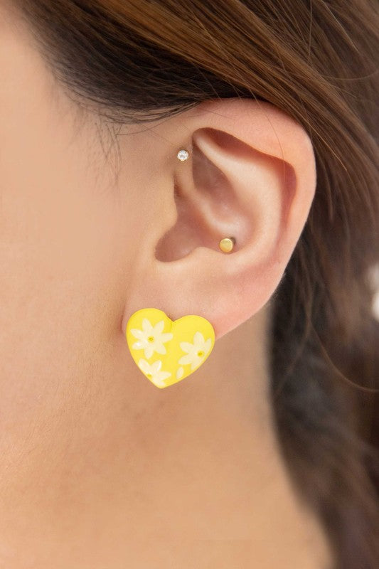 A diagonal line of Flower Lover Stud Earrings with floral patterns on a white background, featuring yellow stud hearts with Sterling Silver Posts.