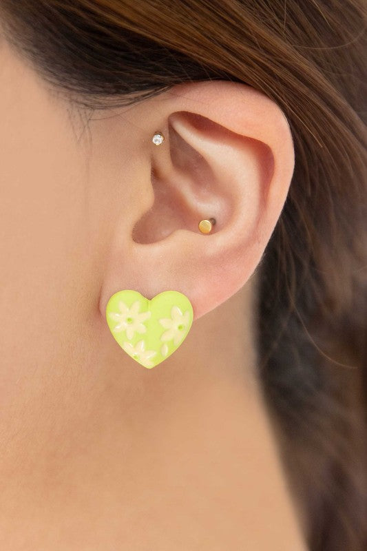 A diagonal line of Flower Lover Stud Earrings with floral patterns on a white background, featuring yellow stud hearts with Sterling Silver Posts.