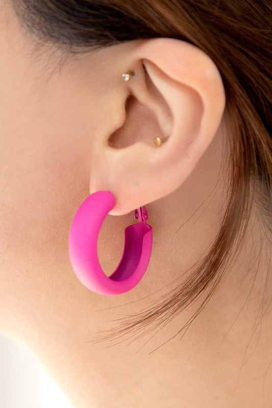 Two pairs of Eclectic Hoop Earrings, one neon pink and one yellow, against a white background.