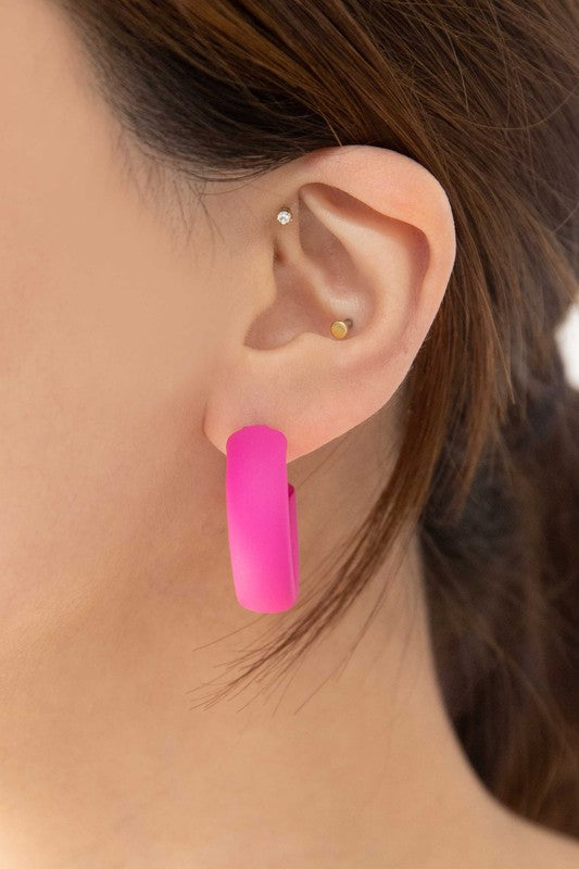 Two pairs of Eclectic Hoop Earrings, one neon pink and one yellow, against a white background.