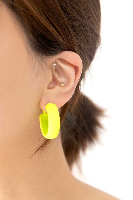 Two pairs of Eclectic Hoop Earrings, one neon pink and one yellow, against a white background.