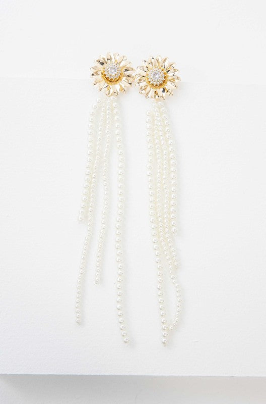 A pair of Dandelion Pearl Drop Earrings with pearl tassels against a white background, featuring 14k gold plating.