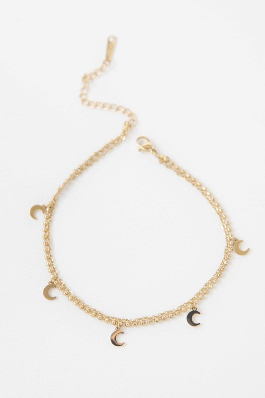 Sentence with Product Name: La Lune Anklet with double-layered crescent moon charms against a white background.
