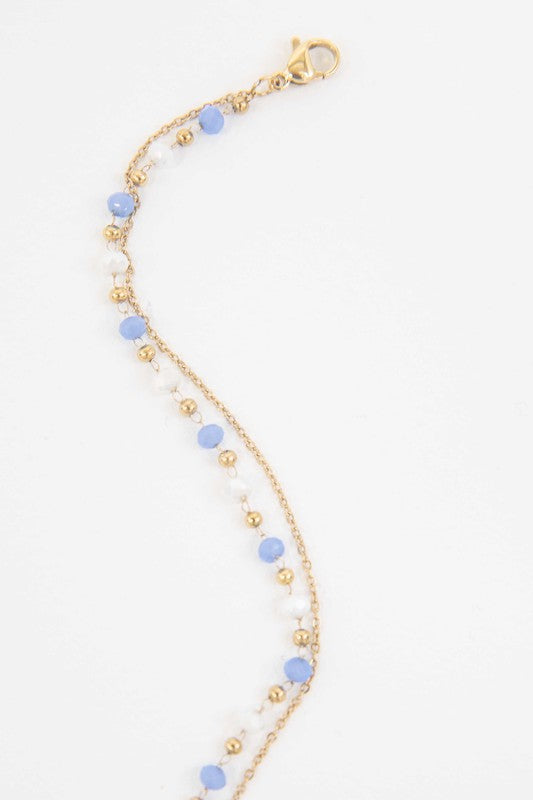 Cana Beaded Bracelet with blue bead accents on a white background and 14k gold plating.