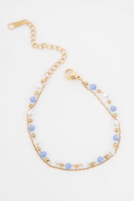 Cana Beaded Bracelet with blue bead accents on a white background and 14k gold plating.