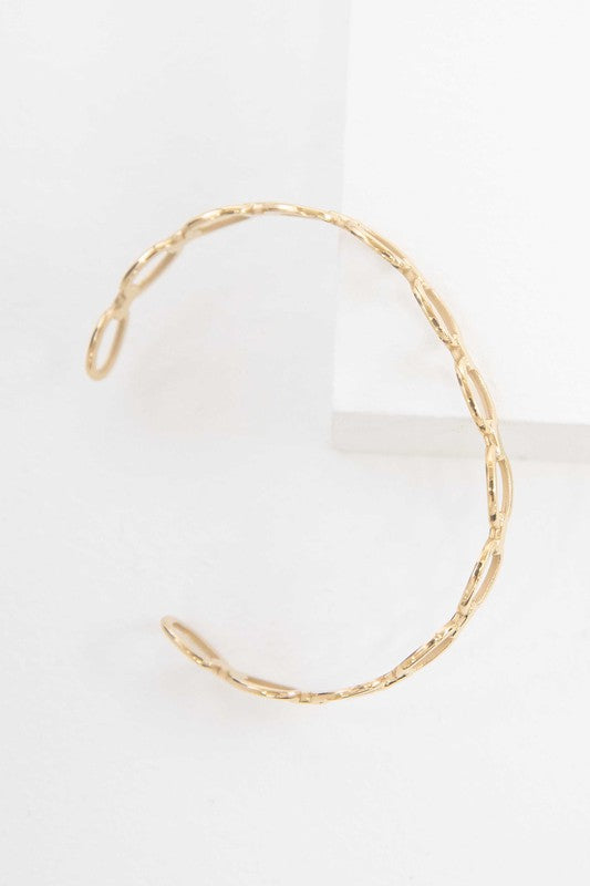 The Oval Link Cuff Bracelet, a 14k gold-plated creation, features a series of oval-shaped links and is displayed on a white background.