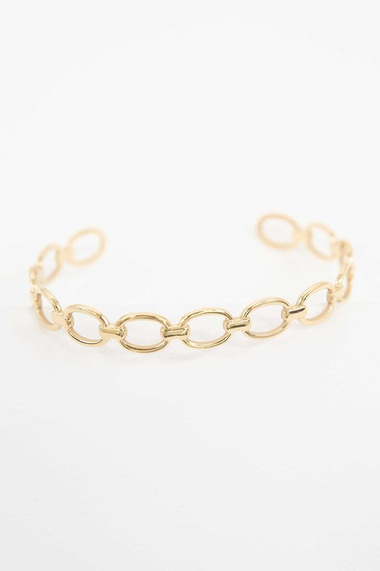 The Oval Link Cuff Bracelet features a delicate gold chain with oval-shaped links and 14k gold plating, showcased on a white background.